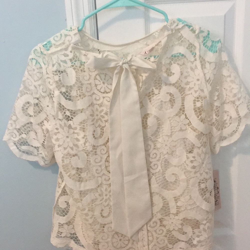 White, lace shirt with a bow on the back.
